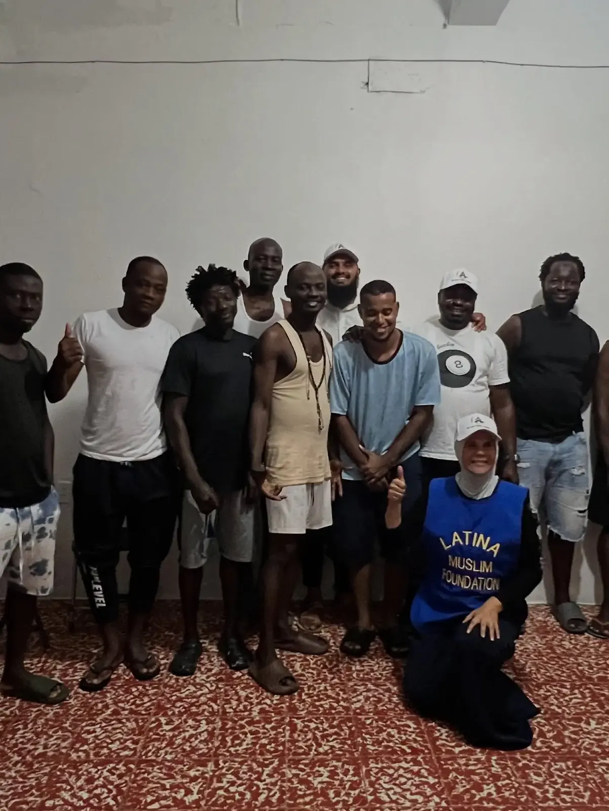 Smiling residents and a Latina Muslim Foundation volunteer together at ALMA's shelter in Tapachula