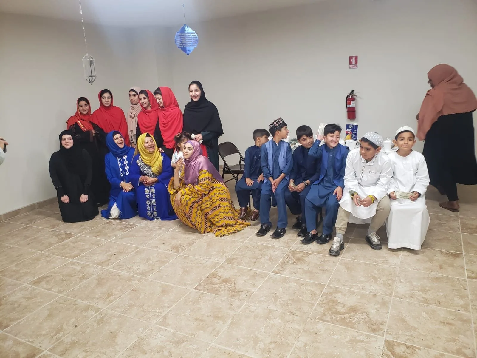 Women, girls and boys from the shelter community gathered together in festive clothes