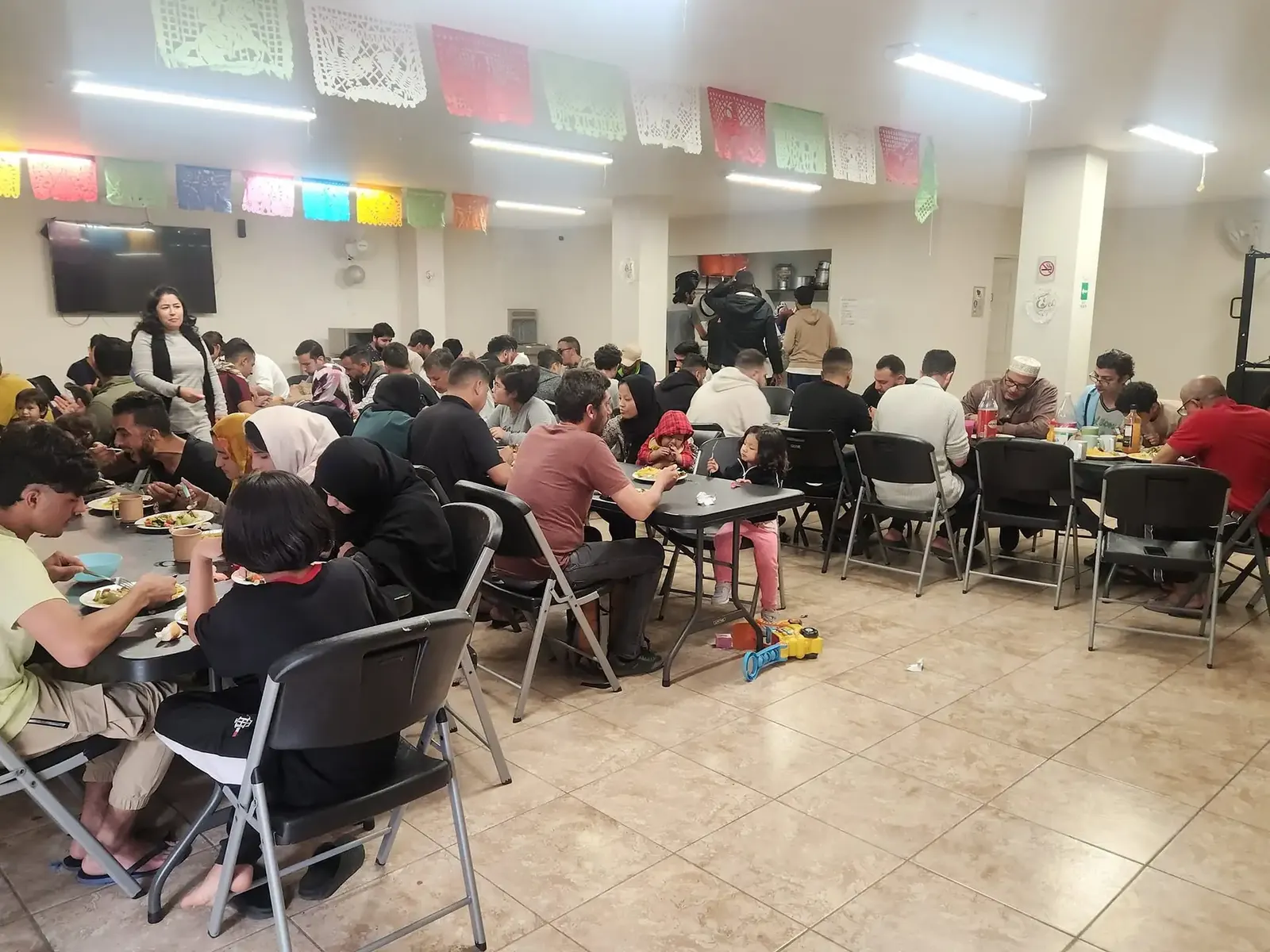 Families and refugees sharing a meal in the dining hall of the As-Sabil shelter in Tijuana